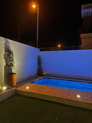 a swimming pool in a backyard at night at Modern House private Pool, Rooftop & beach view in Mohammedia