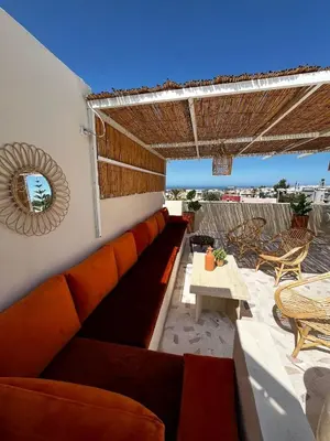 a patio with a couch and a table and chairs at Modern House private Pool, Rooftop & beach view in Mohammedia
