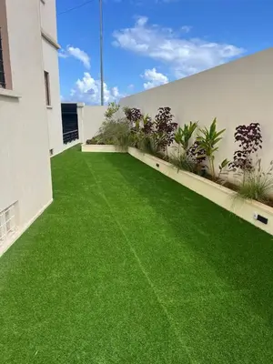 a yard with green grass on the side of a building at Modern House private Pool, Rooftop & beach view in Mohammedia