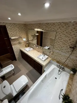 a bathroom with two sinks and a tub and two toilets at Modern House private Pool, Rooftop & beach view in Mohammedia