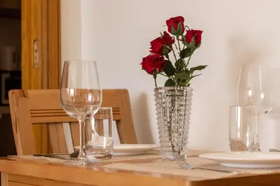 a table with two wine glasses and a vase with red roses at Panorama sur l'infini in Casablanca