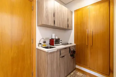 a small kitchen with wooden cabinets and a microwave at Panorama sur l'infini in Casablanca