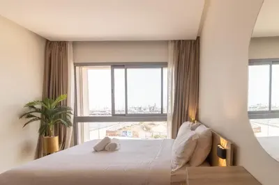 a bedroom with a bed and a large window at Panorama sur l'infini in Casablanca
