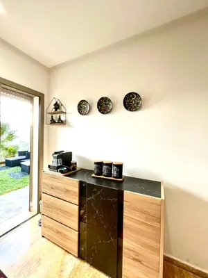 a kitchen with a counter with bowls on the wall at Seaside escape beautiful garden apartment in Sidi Rahal