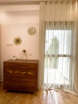 a room with a dresser and a large window at Seaside escape beautiful garden apartment in Sidi Rahal