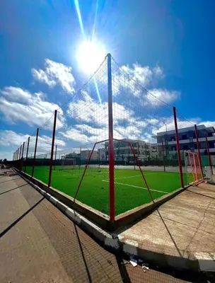 a soccer net on a soccer field with the sun at Seaside escape beautiful garden apartment in Sidi Rahal