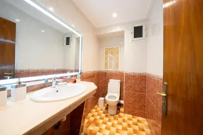 a bathroom with a sink and a toilet and a mirror at Large & Comfy 3 bedrooms in Casablanca Center in Casablanca