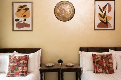 a room with two beds with pillows and a table at Large & Comfy 3 bedrooms in Casablanca Center in Casablanca