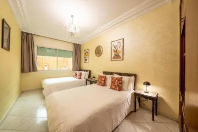 a bedroom with two beds and a chandelier at Large & Comfy 3 bedrooms in Casablanca Center in Casablanca