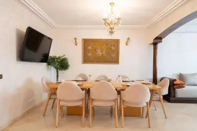 a dining room with a wooden table and chairs at Large & Comfy 3 bedrooms in Casablanca Center in Casablanca