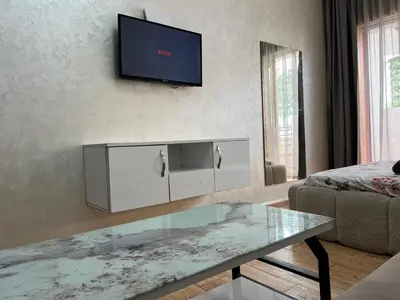 a living room with a table and a tv on the wall at Nice studio in Rabat