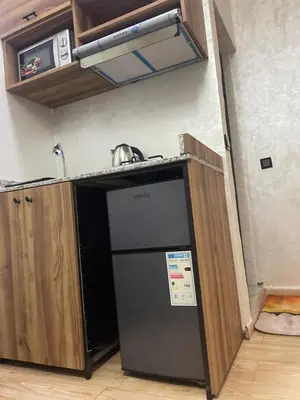 a kitchen with a black refrigerator and a microwave at Nice studio in Rabat