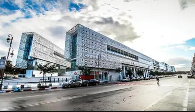 a large building with two towers on a city street at Nice studio in Rabat