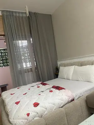 a bed with a white blanket with red hearts on it at Nice studio in Rabat