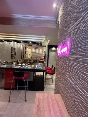 a restaurant with a counter and a pink sign on a wall at Apartment Romandie in Casablanca