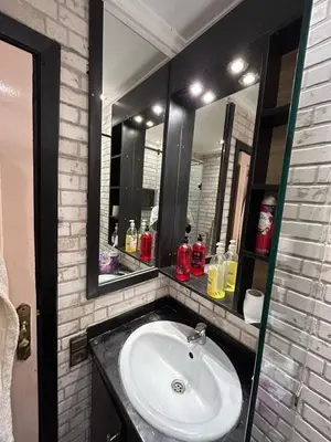 a bathroom with a sink and two mirrors at Apartment Romandie in Casablanca