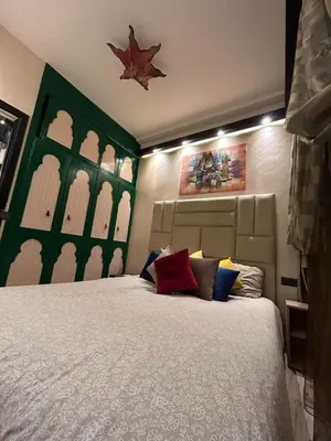a bedroom with a large bed with red and blue pillows at Apartment Romandie in Casablanca