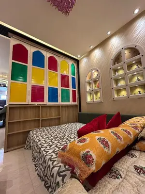 a bedroom with colorful windows and a bed at Apartment Romandie in Casablanca