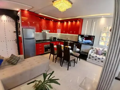 a kitchen with red cabinets and a table and chairs at Superbe appartement corniche in Casablanca