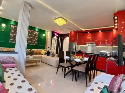 a kitchen and a living room with red cabinets at Superbe appartement corniche in Casablanca