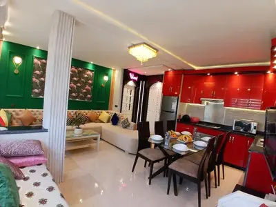 a kitchen and a living room with red cabinets at Superbe appartement corniche in Casablanca