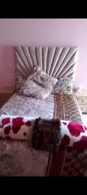 a bedroom with a bed with a white and red comforter at Mansbay in O Ben Slimane
