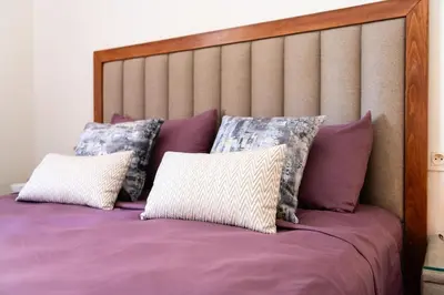 a bed with purple sheets and pillows at Ocean Apartment in Rabat
