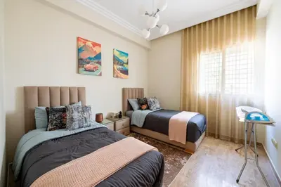 a bedroom with two beds and a window at Ocean Apartment in Rabat