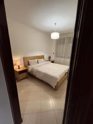 a bedroom with a bed and a table and a lamp at Chic Studio in Agdal Walk to Everything in Rabat