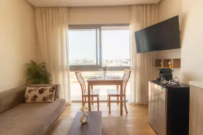 a living room with a couch and a table with chairs at Marina Lifestyle ! in Casablanca