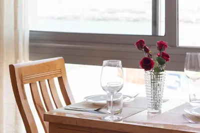 a table with a vase of roses and glasses on it at Marina Lifestyle ! in Casablanca