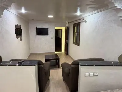 a living room with couches and a table and a tv at Charmante Maison Traditionnelle au Cœur de la Médina, 5 min de Casa Port in Casablanca