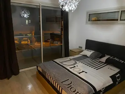 a bedroom with a bed and a window and a chandelier at Prestigia golf city bouskoura in Casablanca