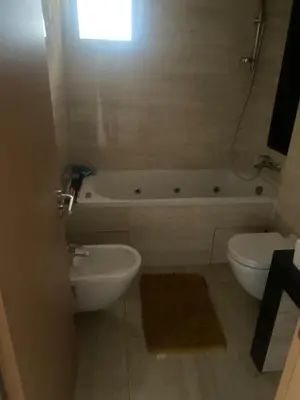 a bathroom with a tub and a toilet and a sink at Prestigia golf city bouskoura in Casablanca