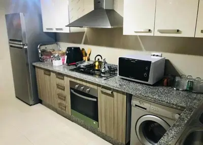 a kitchen with a sink and a stove and a microwave at Prestigia golf city bouskoura in Casablanca
