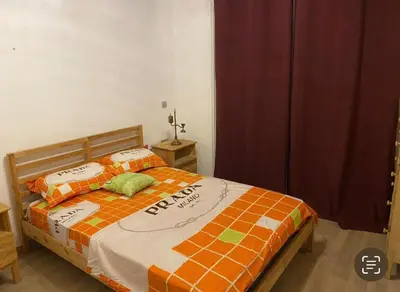 a bedroom with a bed with an orange and white blanket at Prestigia golf city bouskoura in Casablanca