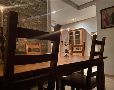 a dining room with a wooden table and chairs at Prestigia golf city bouskoura in Casablanca