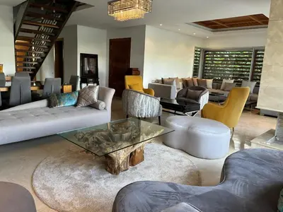 a living room with couches and a table and chairs at Villa Bouznika Bay by Saloua in Bouznika