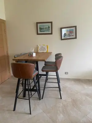 a wooden table and two chairs in a room at Casabay Sidi Rahal, à 2mn de la mer en bord de piscine et jardin in Sidi Rahal