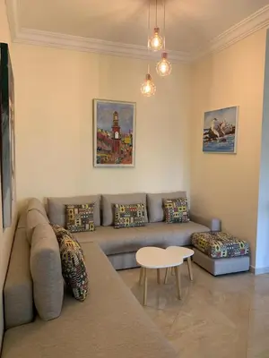 a living room with a couch and a table at Casabay Sidi Rahal, à 2mn de la mer en bord de piscine et jardin in Sidi Rahal