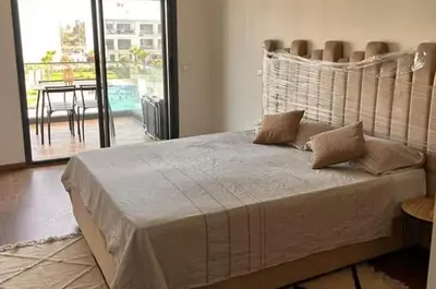 a bedroom with a large bed and a balcony at résidence à louer in Nouaceur
