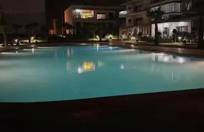 a large swimming pool at night with blue illumination at résidence à louer in Nouaceur