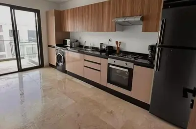 a kitchen with a stove and a refrigerator at résidence à louer in Nouaceur