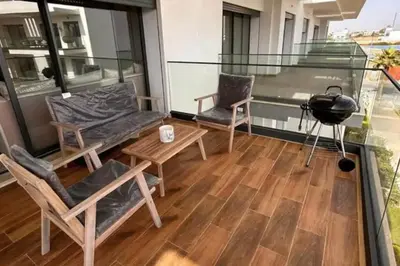 a balcony with chairs and a table and a grill at résidence à louer in Nouaceur