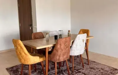 a dining room table with chairs and a wooden table at résidence à louer in Nouaceur