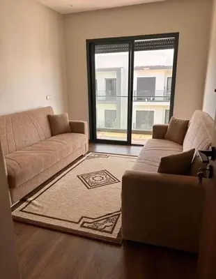 a living room with a couch and a large window at résidence à louer in Nouaceur