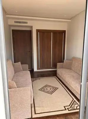 a living room with two couches and a rug at résidence à louer in Nouaceur