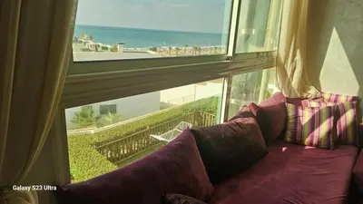 a purple couch sitting in front of a large window at Appartement de plage front de mer in Tamaris