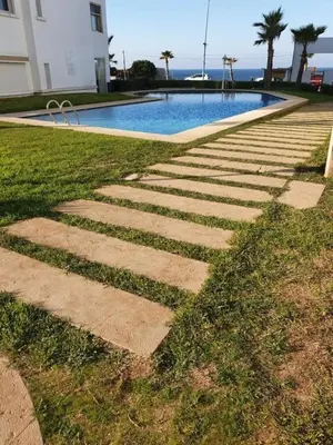 a stepping stone path leading to a swimming pool at Appartement de plage front de mer in Tamaris