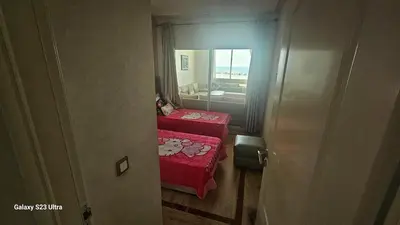 a small room with two beds and a mirror at Appartement de plage front de mer in Tamaris